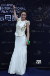 郑亦桐身穿白色长裙尽显甜美 蓝色地毯展露微笑